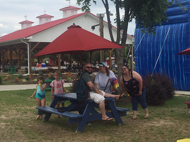 People sitting at a picnic table at the Family Fun Day in Youngsville